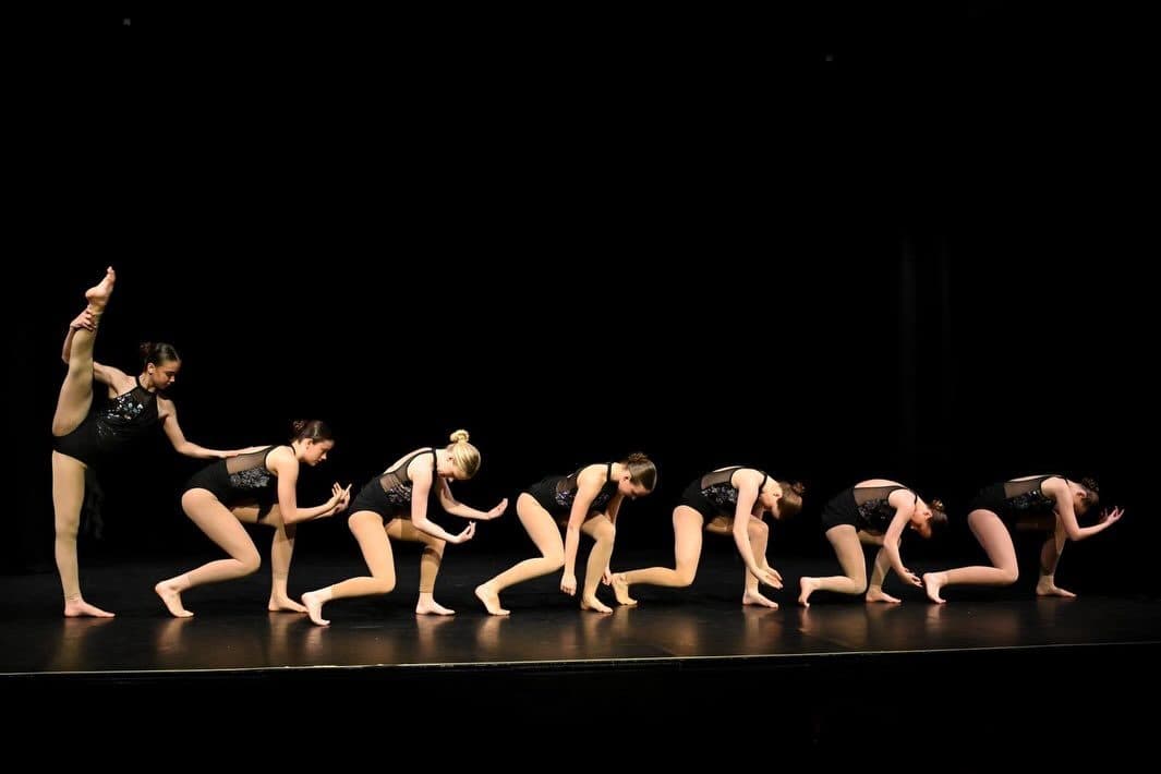 Ensemble holding a low pose in a line