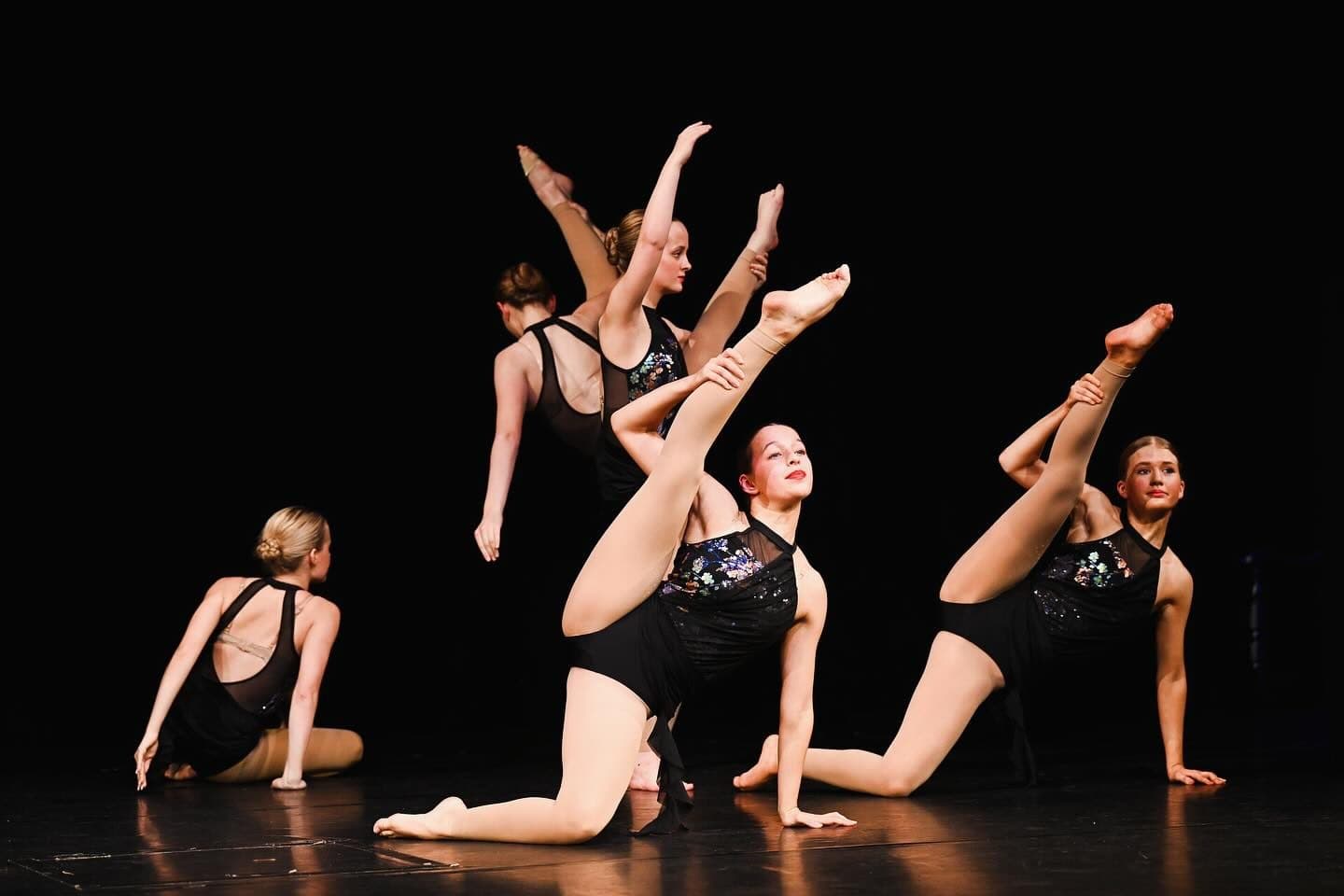 Ensemble in grey holding acrobatic poses